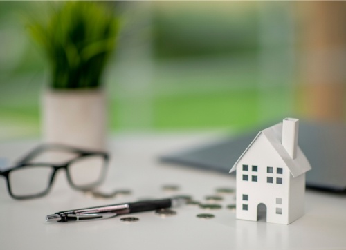 paper house, coins, pen, glasses - borrowing power and tax cuts