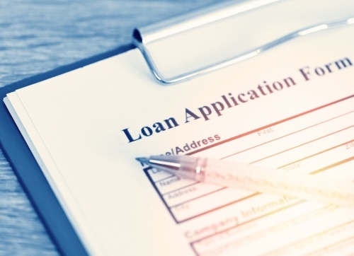  Blank loan application form on a clipboard with a pen on top
